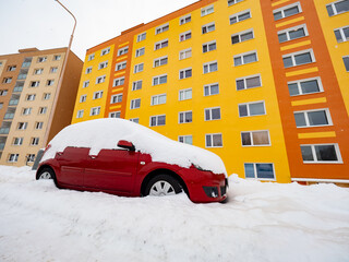 Lost car under huge snow and yellow orange resident house