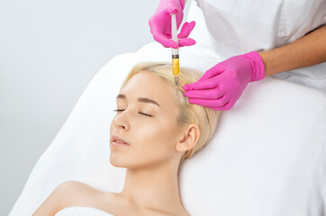 Cosmetologist does prp therapy against hair loss and anti-dandruff of a beautiful woman in a beauty...