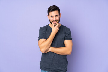 Caucasian handsome man thinking over isolated purple background