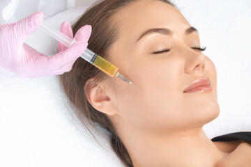 Cosmetologist does prp therapy on the face of a beautiful woman in a beauty salon. Cosmetology...