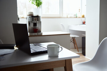 Freelancer home workplace. Laptop on table in office interior. Online job and remote work.