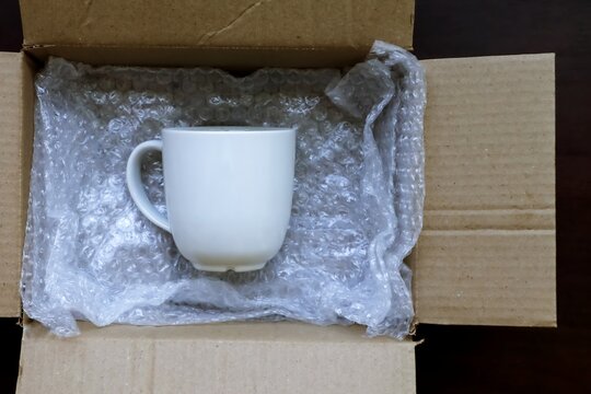 White Ceramic Cup And Bubble Plastic Wrap, Packaged Shockproof To Protect The Cup From Shattering, Prevent Product Damage Or Broken And Delivered In A Cardboard Parcel Box.