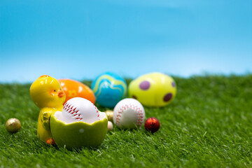 Baseball with Easter eggs are on green grass for Easter Holiday