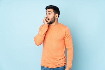 Caucasian handsome man is a little bit nervous over isolated blue background