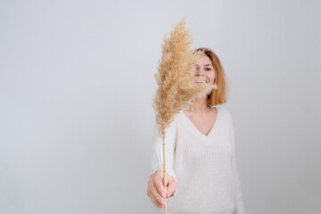 The woman holds the pampas grass in hands. Reed stem, dried pampas grass, decorative feather...