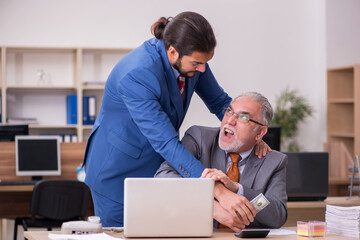 Obraz premium Old male boss and young male employee in remuneration concept