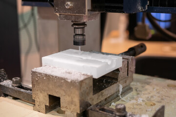 Turning milling machine cutting white acrylic artificial stone workpiece at factory, exhibition: close up. Stoneworking, engraving, industrial, equipment, production, technology, manufacturing concept