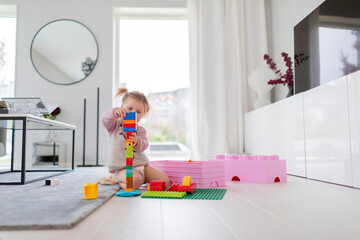 Toddler girl playing with building blocks