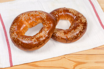 Ring shaped bread rolls sprinkled with sesame on a napkin