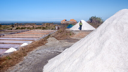 Fototapeta na wymiar Huge salt mountain in foreground with salt ponds in background