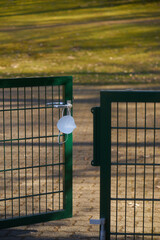 corona mask hanging at half open fence door symbolising death by covid19
