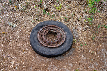 Old tyre and rim dumped outside