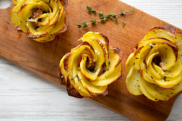 Homemade Potato Roses on a rustic wooden board, top view. Flat lay, overhead, from above.