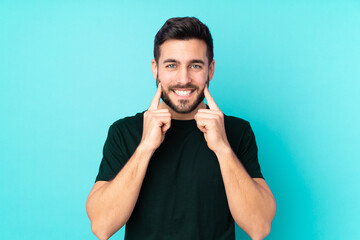 Caucasian handsome man isolated on blue background smiling with a happy and pleasant expression