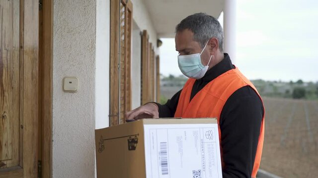 Delivery man with mask delivers package to customer. He is at the right address and the customer receives the package.