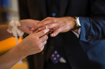 Obraz na płótnie Canvas Wedding rings in the hands of the bride and groom. Wearing wedding rings, gentle touches, hands of the bride
