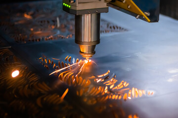 Automatic cnc laser cutting machine working with sheet metal with sparks at factory, plant....
