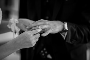 Wedding rings in the hands of the bride and groom. Wearing wedding rings, gentle touches, hands of the bride