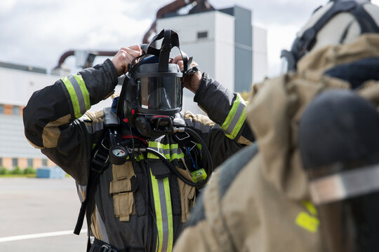 Firefighter putting breathing equipment on