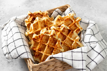 Belgian or Brussels waffles. Homemade waffles in a basket on the light gray kitchen table....