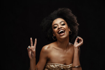 Cheerful african american woman in party dress showing peace sign