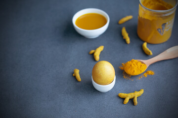 Instructions how to color easter eggs with natural dye. Yellow color from turmeric. Copy space. Grey background