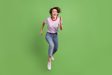 Full length body size view of pretty cheerful girl jumping running movement isolated over green pastel color background