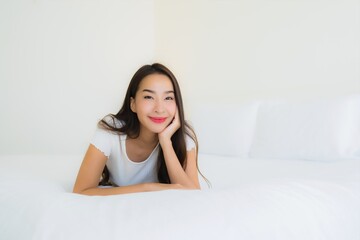 Obraz na płótnie Canvas Portrait beautiful young asian woman relax happy smile on bed with white pillow blanket