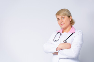 Profile photo of senior blonde family doc, patients consultation, friendly smiling, reliable, clinic virology, arms crossed wear white lab coat and stethoscope isolated grey color background