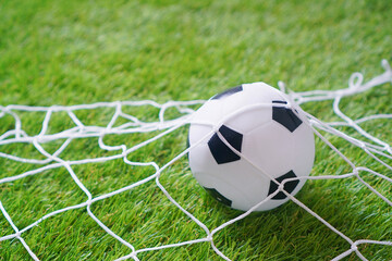 Baby mini football background with a football goal and soccer ball on the soft artificial grass