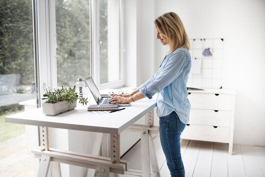 Businesswoman working at ergonomic standing desk.