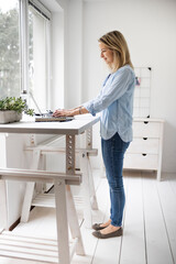 Businesswoman working at ergonomic standing desk.