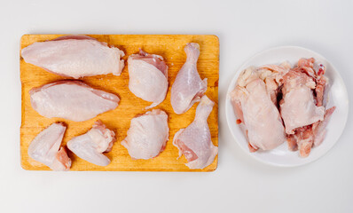 butchered carcass of raw chicken on a wooden cutting board on a white background
