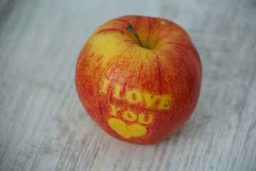 I love you written red apple on a wooden table. Valentine's day composition 
