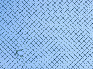 Decorative wire mesh of fence with hole isolated blue sky background