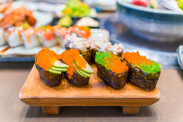 Close-up of Japanese sushi and sashimi food. Maki ands rolls with tuna, salmon, and fish egg. Top view of assorted sushi. Side view of assorted sashimi with tuna, salmon, shrimp, fish egg. 