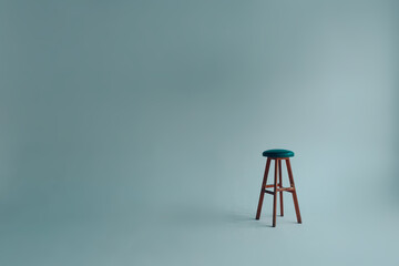 Bar stool with upholstered backless seat in an empty white room on a gray background