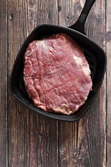 Uncooked Flank steak. Raw beef meat.  Dark wooden background, copy space