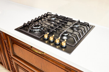 Modern gas hob stove made of steel and cast iron with golden controls using natural gas or propane...