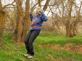 WOMAN CROSSING A RIVER ON A CABLE