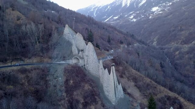 Car driving through Euseigne pyramids, Switzerland. Aerial circling