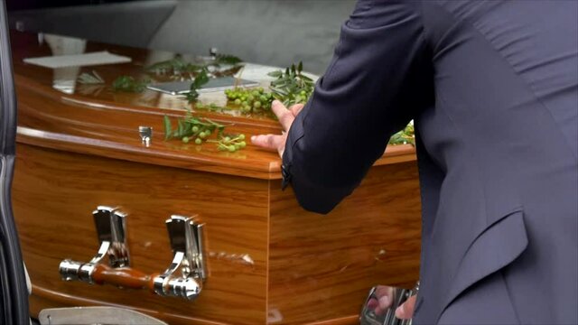 closeup shot of a funeral casket in a hearse or chapel or burial at cemetery