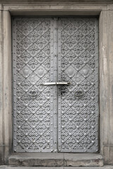 Vintage metal door with cast patterns and monogram.