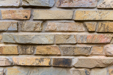Color painted brick wall. Texture of old dark brown, orange and yellow brick wall panoramic backgorund