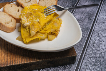 Spanish omelette with potatoes and onion, typical Spanish cuisine. Spanish tortilla. Dark wood background
