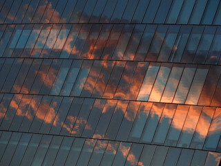 architecture of glass building with reflection of sky sunset