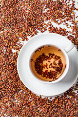 Brown rice tea in white cup, copy space, top view.