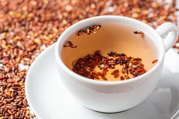 Brown rice tea in white cup, close up.