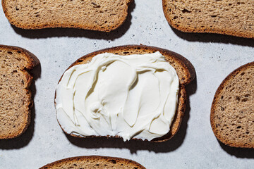 Pattern of pieces of bread and cream cheese toast on gray background. Breakfast concept.