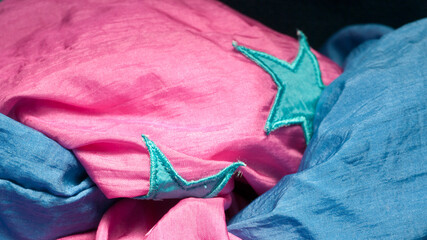 Parches de estrella azules cosidos en tejido táctel azul y rosa